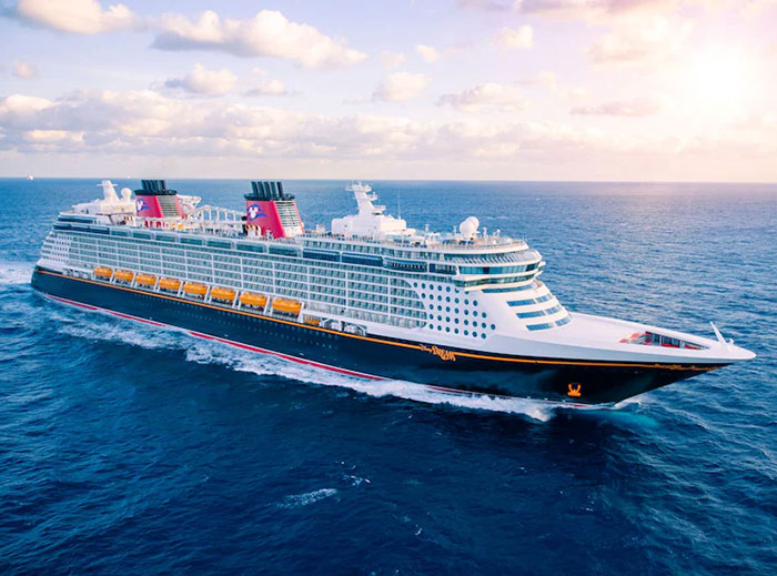 Large Disney cruise ship sailing on the ocean under a cloudy sky, related to girl's fall incident on Disney cruise ship.