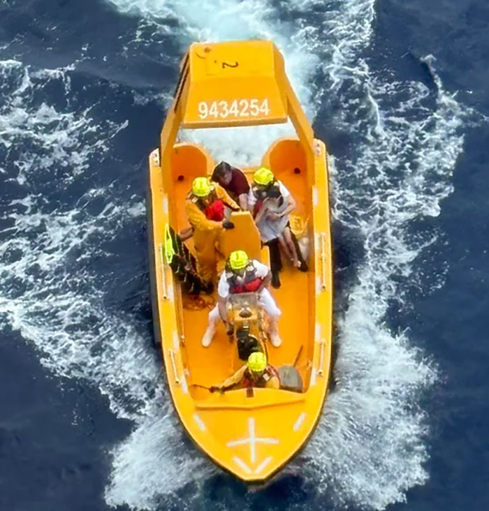 Rescue team in a yellow boat aiding a girl after her horrifying fall from a Disney cruise ship at sea.