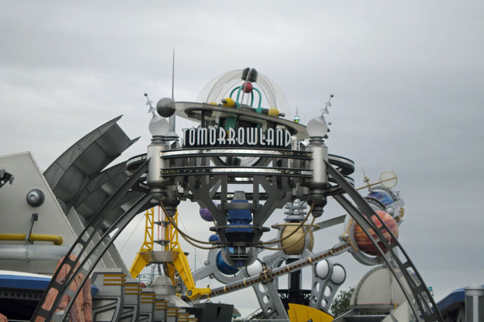 Tomorrowland entrance at Disneyland showing the outdated attraction with a cloudy sky background and futuristic design elements.