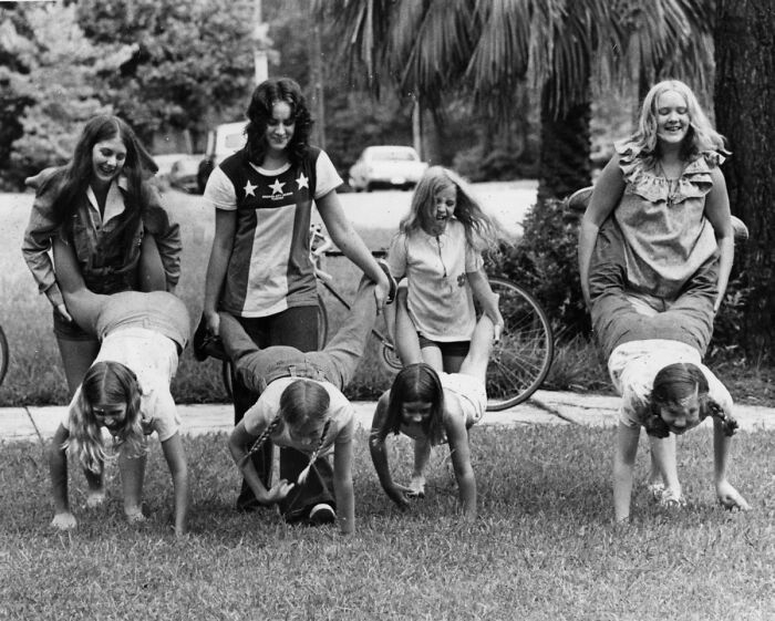 Girls in Florida playing wheelbarrow race outdoors, showcasing women breaking barriers and enjoying fun activities in the 1970s.