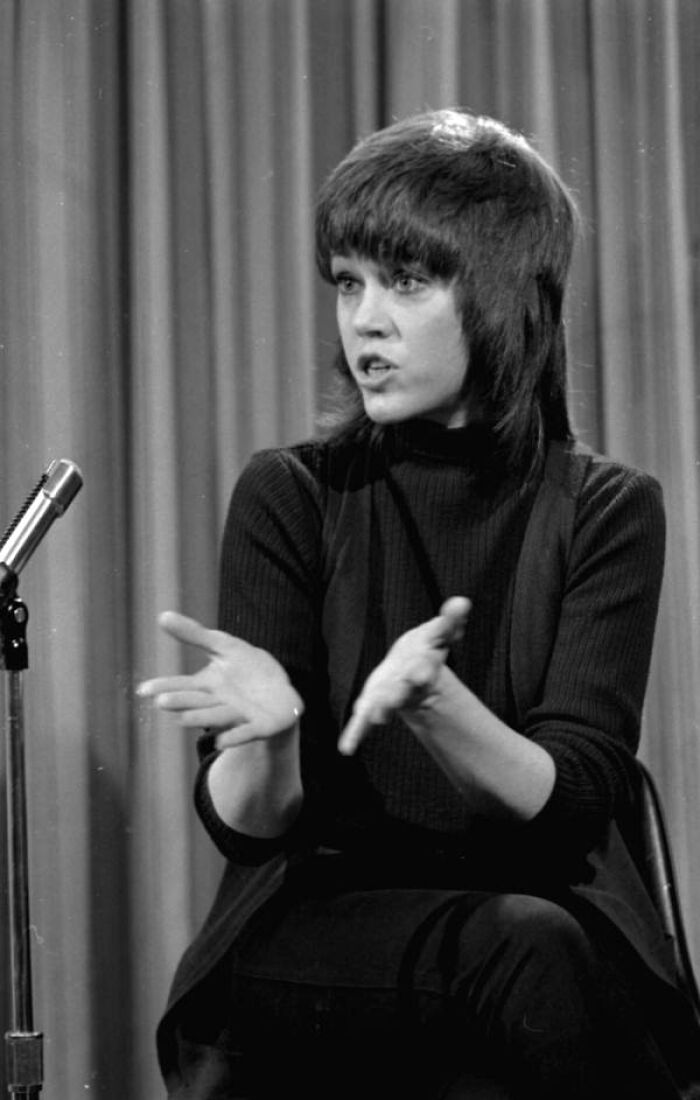 Woman in Florida speaking passionately at a microphone, breaking barriers in the 1970s with confident expression and gestures.