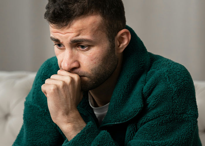 Worried man in green jacket sitting indoors, reflecting on delayed help and facing shocking medical consequences. - 18