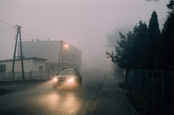 Car driving on a foggy street at night with headlights on, illustrating people realizing they were doing something wrong. - 38