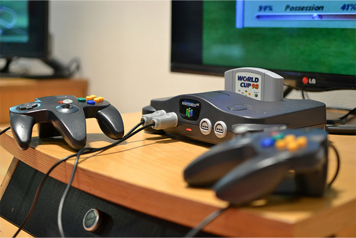 Retro Nintendo 64 console and controllers on a wooden table, illustrating moments people realized they were doing something wrong. - 43