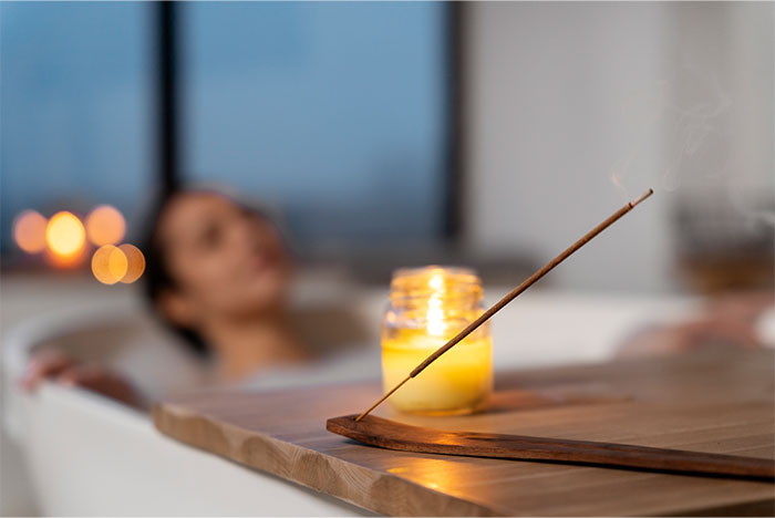 Woman relaxing in a bathtub with a lit incense stick and candle, reflecting on not proud moments and mistakes. - 16