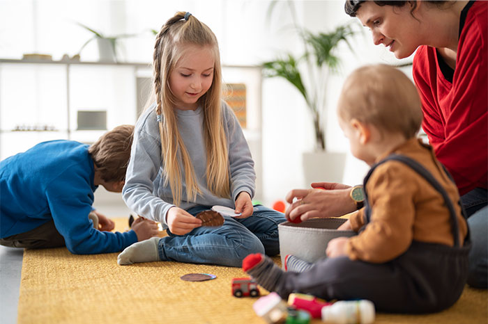 Children and an adult interacting on the floor, showing moments where people decided to stop helping others out. - 22