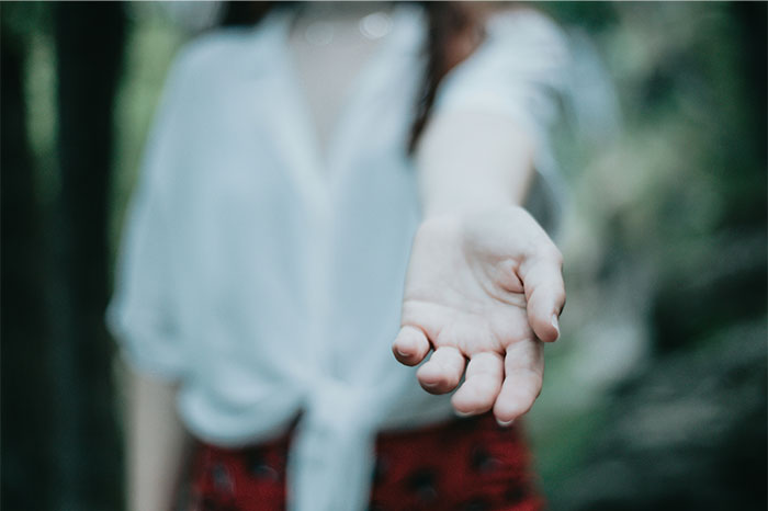 A person reaching out with an open hand symbolizing moments people decided to stop helping others. - 43