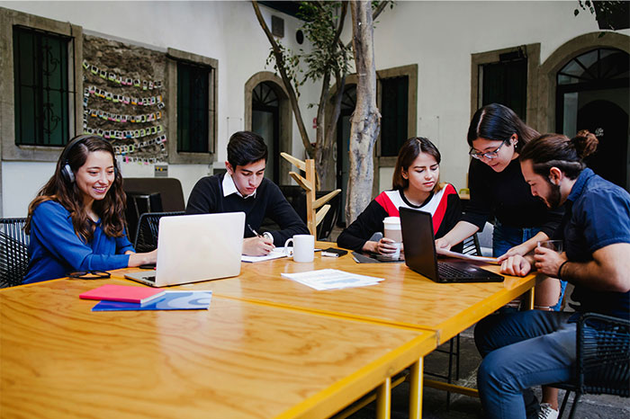 Group of people working together at a table, showing moments when people decided to stop helping others out. - 35