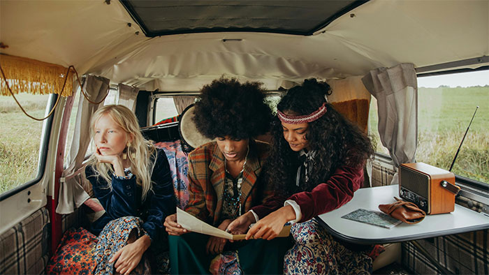 Three young people in a van, with one looking upset while the others focus on a map, capturing moments when people stopped helping. - 44