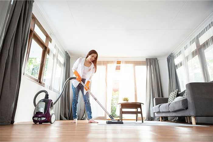 Woman vacuuming living room floor with canister vacuum, illustrating moments people decided to stop helping others out. - 41