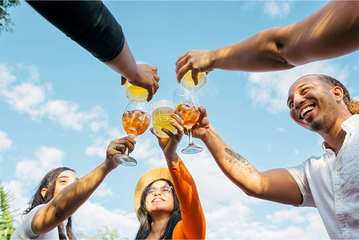 Group of friends raising drinks outdoors, symbolizing a social setting related to drunk wife flashing incident. - 25