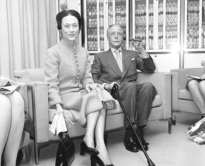 Black and white photo of royals sitting in a room, illustrating royals who walked away from power for love and controversy.