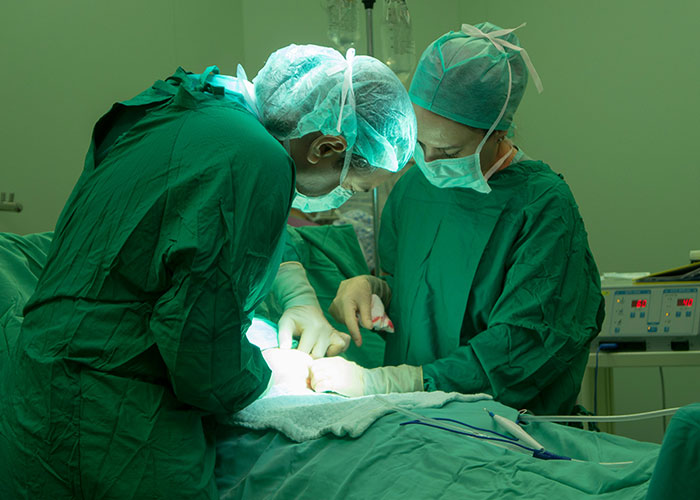 Two surgeons in green scrubs performing a delicate operation, highlighting dumbest reasons that almost cost lives.