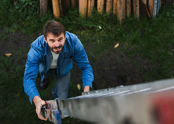 Man climbing a ladder outdoors, illustrating one of the dumbest reasons that almost cost people their lives.