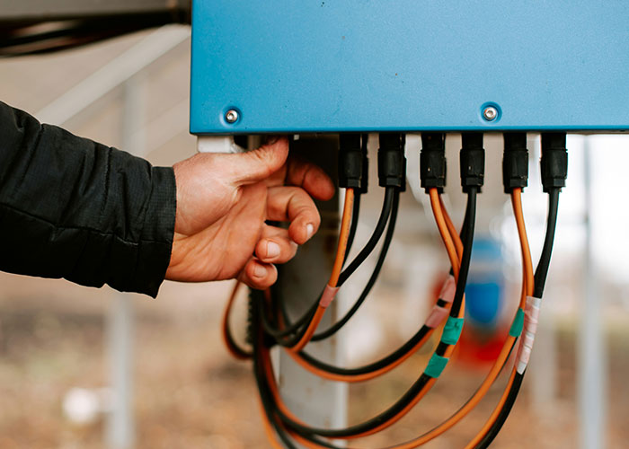 Hand reaching to unplug cables from an electrical box, illustrating dumbest reasons people almost lost their lives.