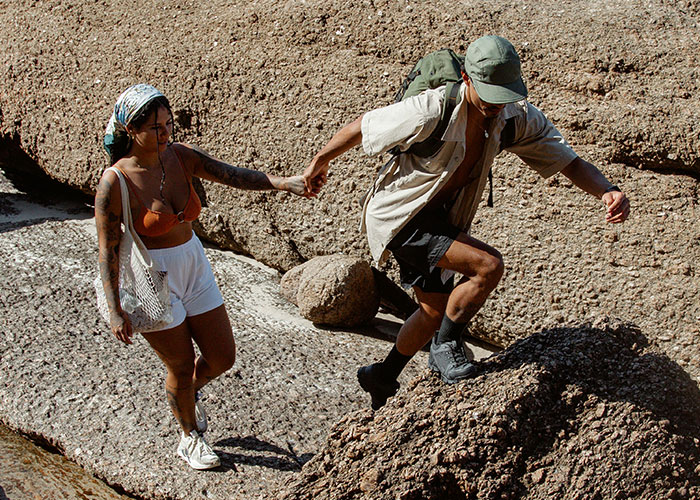 A couple navigating rocky terrain outdoors, illustrating risky moments leading to dumbest reasons that almost cost lives.