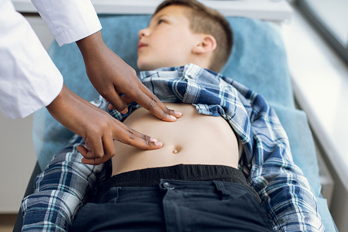 Doctor examining a young boy's abdomen, illustrating dramatic deathbed confessions that surprised viewers by survival. - 12