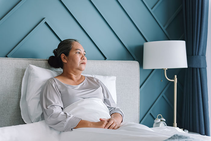 Middle-aged woman lying in bed, appearing thoughtful, representing dramatic deathbed confessions without actual death. - 32