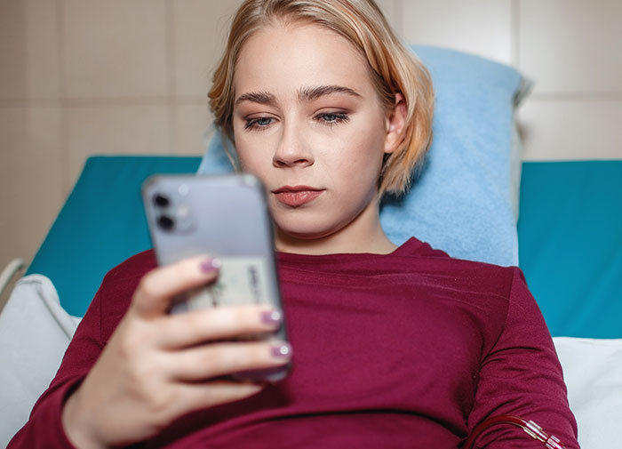 Young woman in a hospital bed using a smartphone, illustrating dramatic deathbed confessions that didn't lead to death. - 20