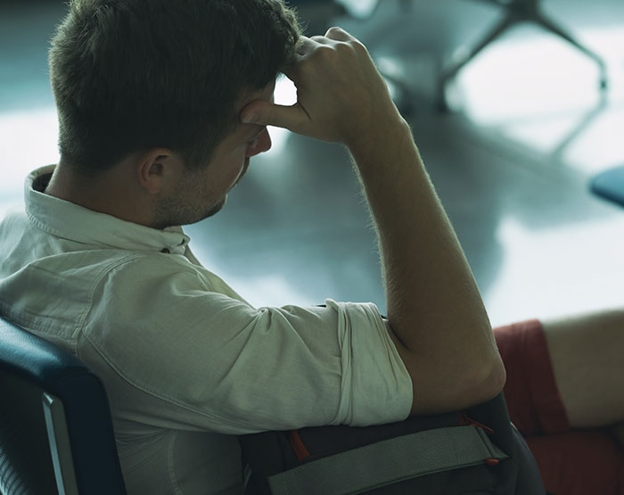 Man sitting with head resting on hand, appearing deep in thought, illustrating dramatic deathbed confessions theme. - 26