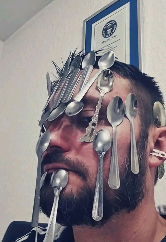 Man with spoons stuck all over his face showcasing an easiest world records to break challenge with time on hands.