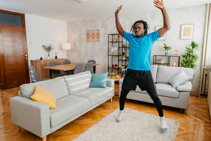 Man in blue shirt attempting a world record challenge at home, demonstrating some of the easiest world records to break.
