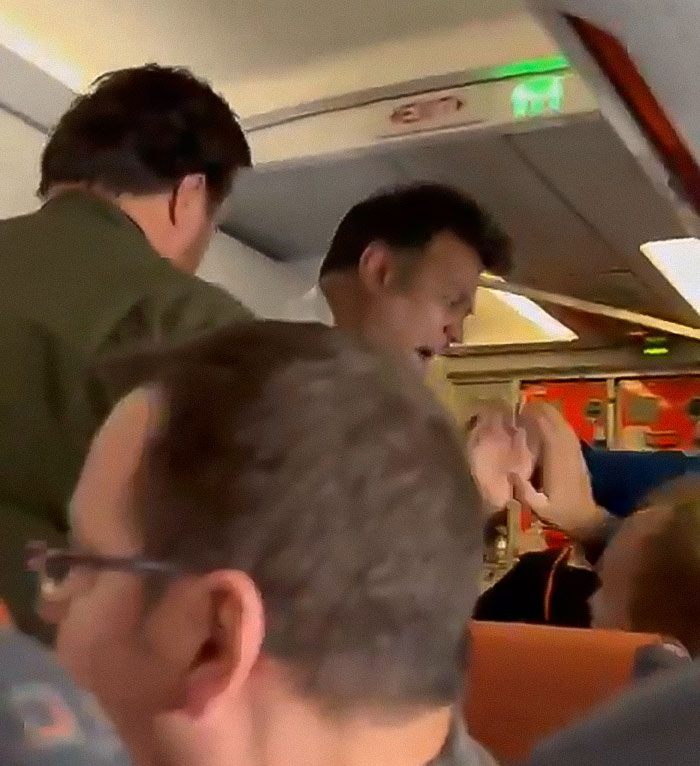 Passenger allegedly threatening to explode plane mid-flight gets tackled by others in a tense cabin confrontation.