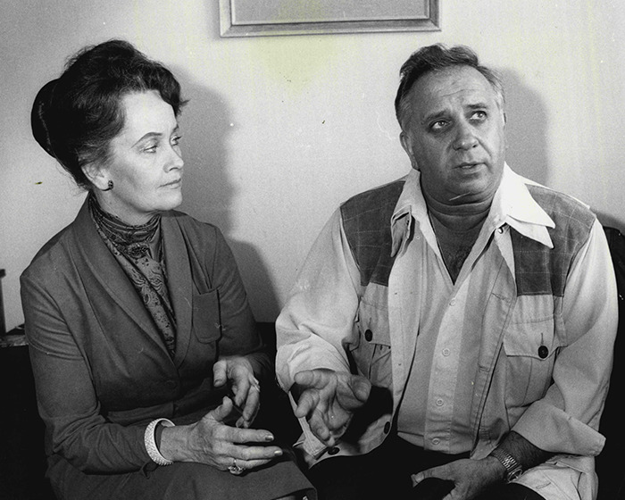Black and white photo of a paranormal investigator and woman in conversation during a serious discussion.