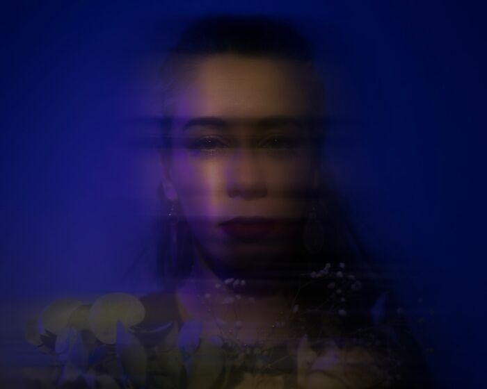Blurry portrait of a woman in dark lighting, symbolizing hard-to-believe stories shared by people.
