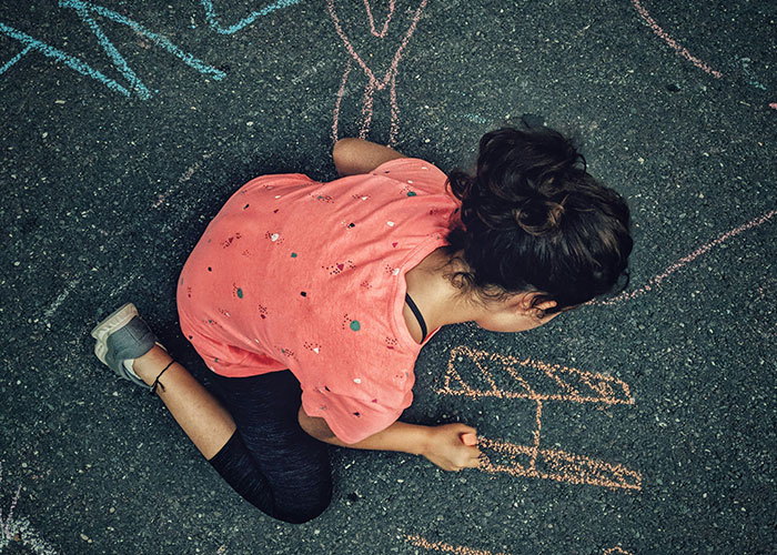 Child drawing with chalk on neighbor&rsquo;s driveway, parents treat driveway like their own backyard causing homeowner frustration