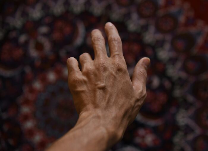 Close-up of a hand reaching out against a patterned background illustrating common lies proven false over and over again.