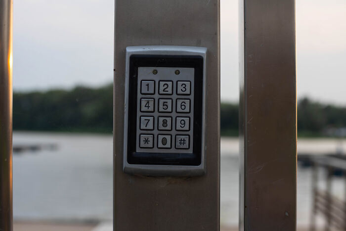 Keypad on a metal post outdoors, representing challenges in escape room employees stories and security puzzles. - 28