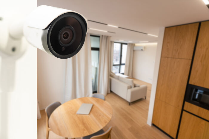 Security camera monitoring a modern escape room employee lounge with wooden furniture and natural light. - 31