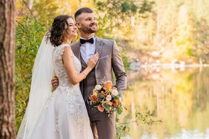 Bride and groom posing by a lake, symbolizing love and unique cultural wedding facts from countries around the world.