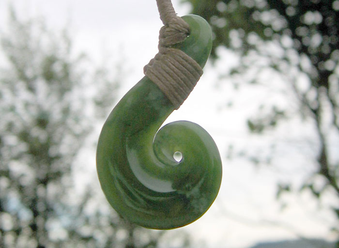 Green stone pendant with rope, a personal and thoughtful gift that feels super expensive, hanging outdoors.