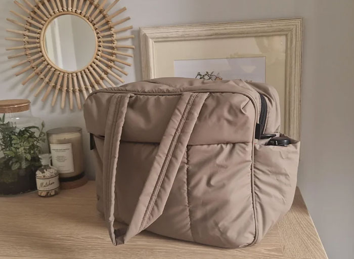 Beige padded bag on wooden surface, styled with home decor, showcasing personal and thoughtful gift ideas.