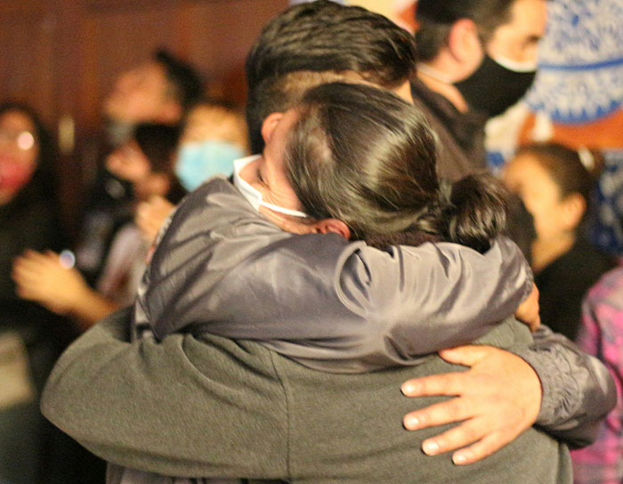 Two people warmly hugging at a social event, symbolizing personal and thoughtful gifts that feel expensive.