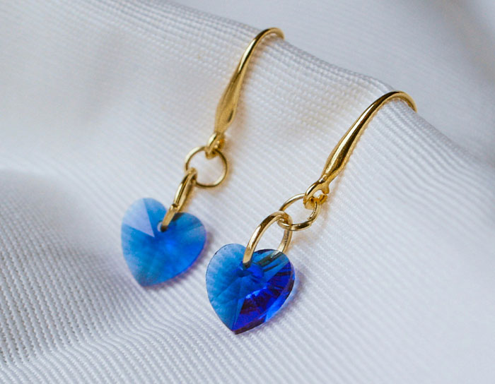 Gold earrings with blue heart-shaped crystals, a personal and thoughtful gift that feels expensive and unique.