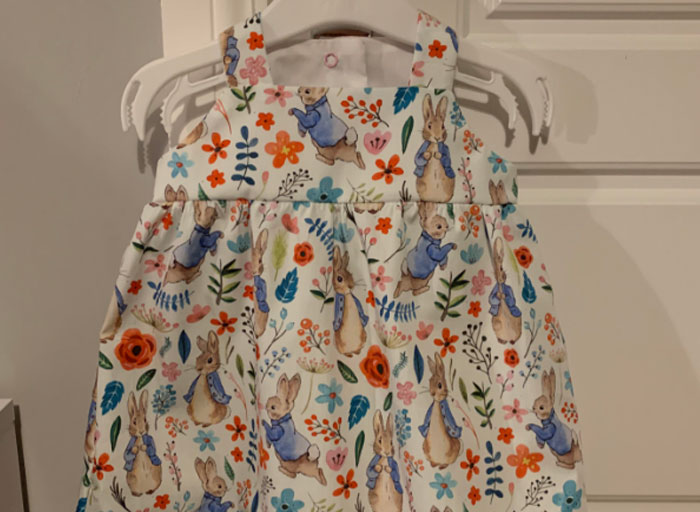 Child's sleeveless dress with colorful bunny and floral print, a personal and thoughtful gift idea that feels expensive.