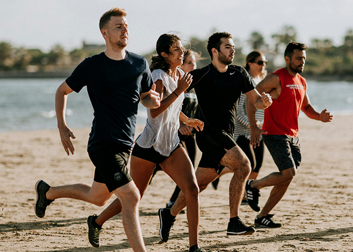 Group of people running on the beach, demonstrating fitness and health advice related to doctors' death machines warnings. - 10