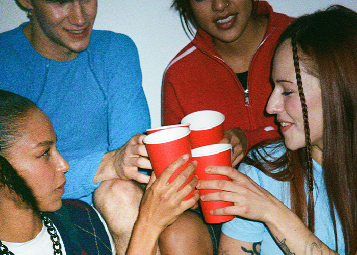 Group of young people holding red cups and toasting, illustrating dangers of death machines and health risks. - 24
