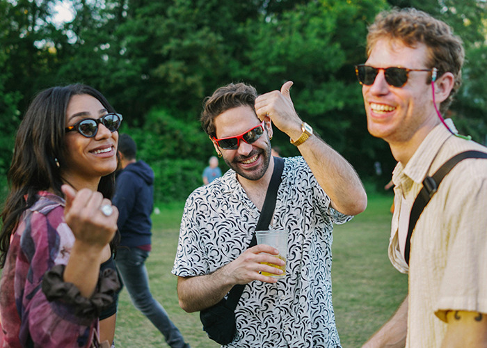 Three friends wearing sunglasses outdoors, smiling and enjoying a social gathering with doctors and health insights theme. - 38