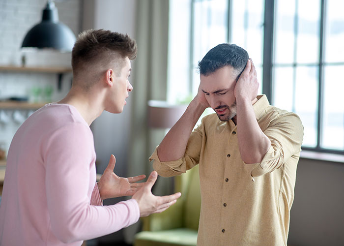 Young man refusing organ donation to father, showing emotional conflict and tension in a bright living room setting.