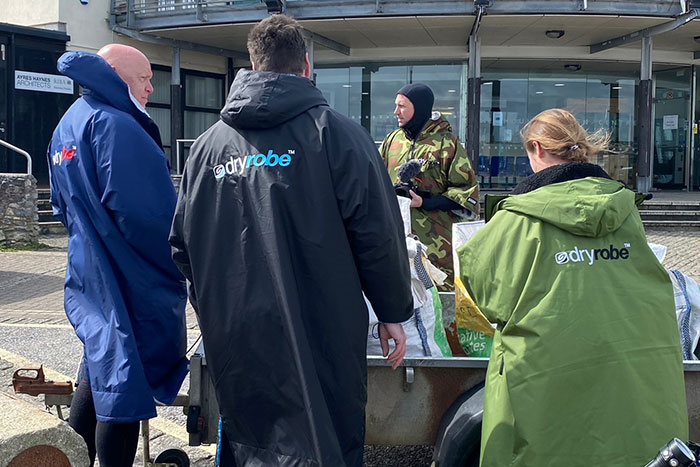 People wearing Dryrobe coats outdoors, illustrating resistance to fashion trend propaganda in casual setting.