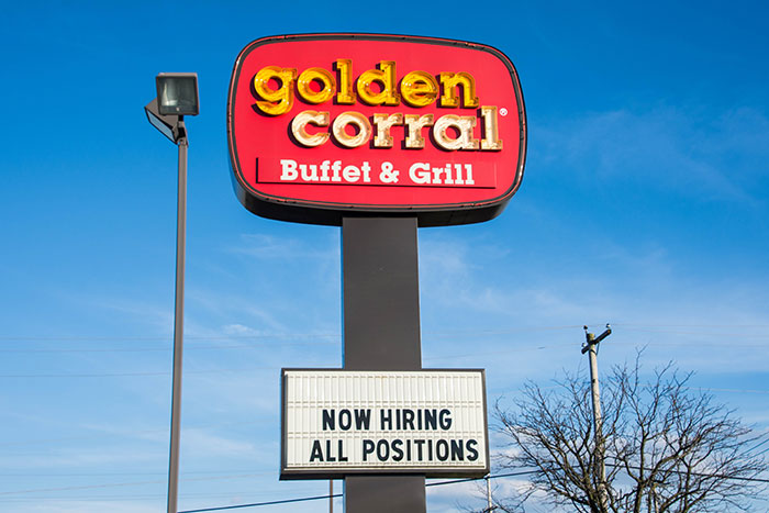 Golden Corral restaurant hiring sign under blue sky, illustrating job experience and quitting on the spot theme.