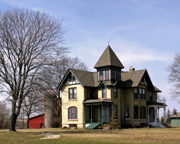 Large old house under clear sky with bare trees, suggesting a home remodel and contractor quotes for renovation.