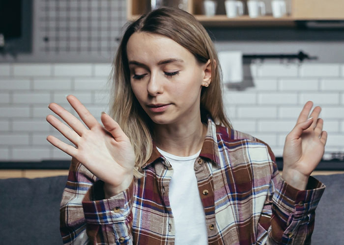Pregnant woman in plaid shirt showing a dismissive gesture indoors, reacting to betrayal and seeking revenge after theft. - 46