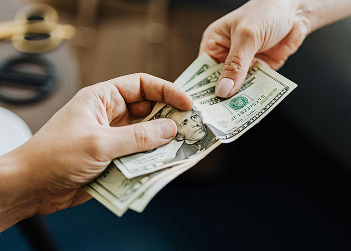 Hands exchanging cash, symbolizing pregnant woman getting revenge after friend’s guest steals money. - 42