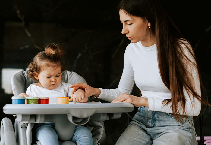 Person upset with friend not paying more after winning the lottery while babysitting a toddler in a high chair. - 1