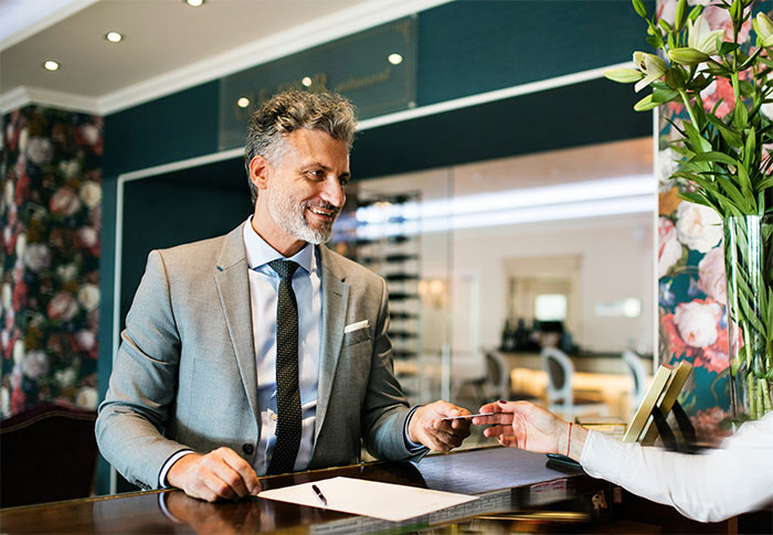 Lawyer in a gray suit exchanging documents with a client, portraying lawyers and defendants in court scenarios.
